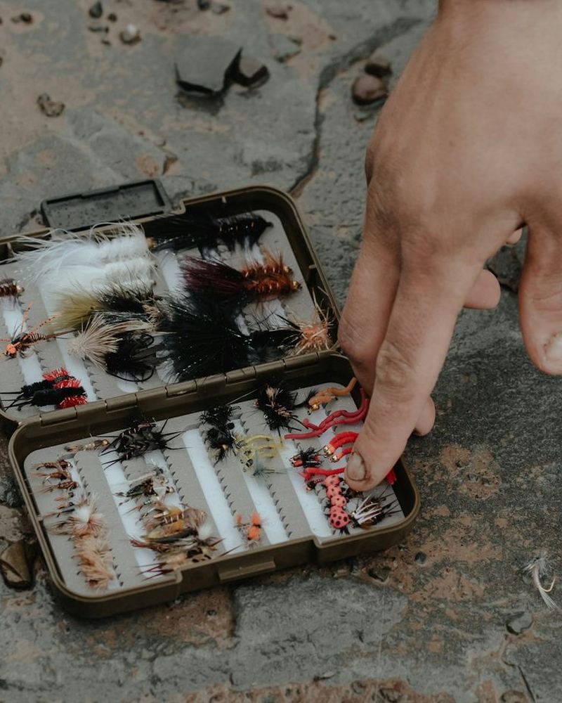 An angler picking a fly from a fly box